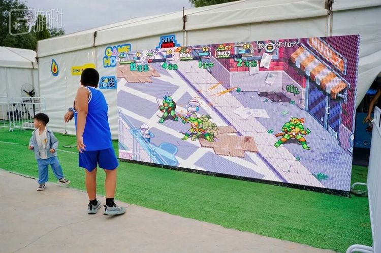 棚外大屏上播放的游戏画面也吸引了不少小朋友围观